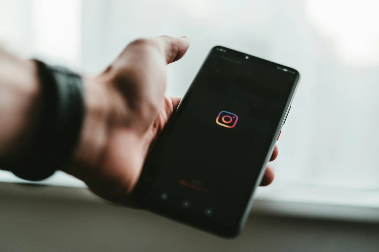 Ekranında Instagram simgesi görünen bir telefonu tutan el