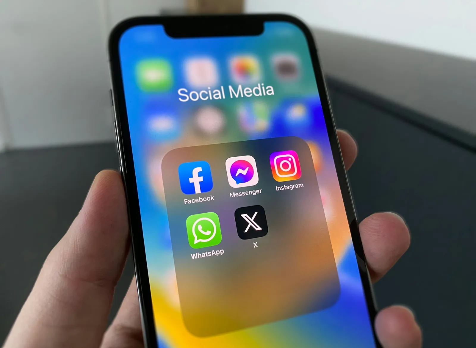 Elde tutulan bir akıllı telefonda Facebook, Instagram, WhatsApp ve X uygulamalarının bulunduğu sosyal medya klasörü