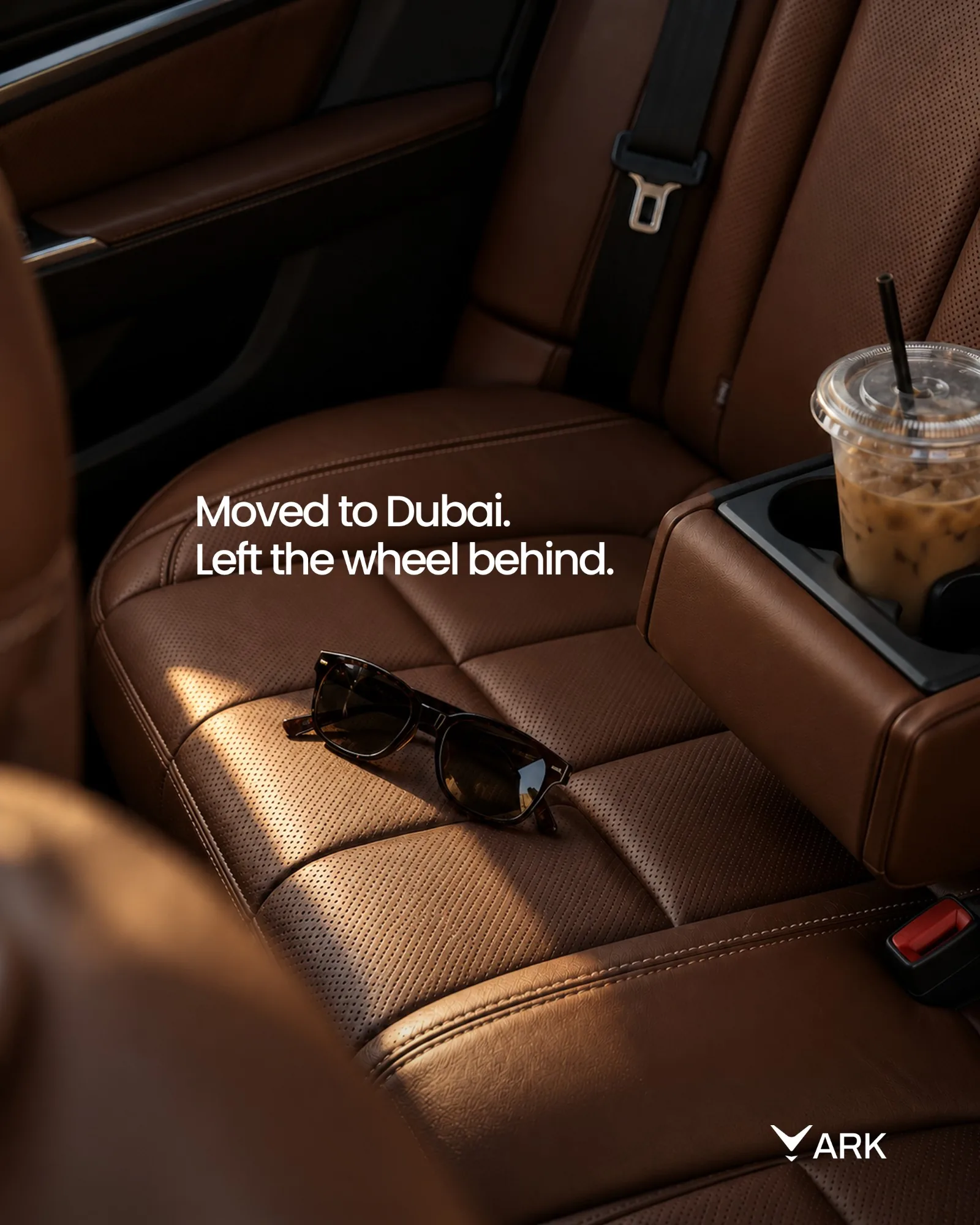 ARK gönderisi: “Moved to Dubai. Left the wheel behind.”, arka koltukta güneş gözlüğü ve buzlu kahve